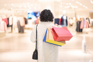 Back view of woman holding shopping bag