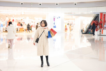 Woman carrying shopping bags in shopping mall