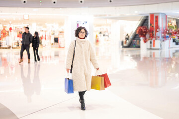 Woman carrying shopping bags in shopping mall