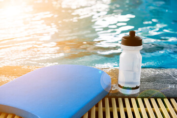 Kick board and water bottle on swimming pool - obrazy, fototapety, plakaty