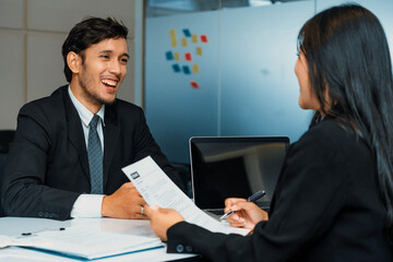 Human resource manager interviewing the male employment candidate in the office room. Happy job interview. Job application, recruitment and Asian labor hiring concept. uds