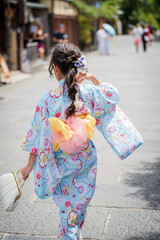 Japanese girl wearing traditional kimono Yukata walking on the street in Kyoto, Japan.