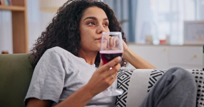 Depression, wine and drunk with bored woman on sofa in living room of home to relax or drink. Sad, frustrated or unhappy and young alcoholic person drinking in apartment with mental health problems