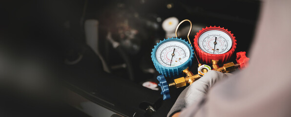 Car mechanic uses air refrigerant meter manifold gauge to check car air conditioner system heat problem and fix repairing and filling air refrigerant. - obrazy, fototapety, plakaty