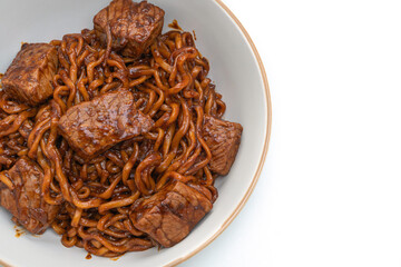 Jjapaguri or Chapaguri, Korean Black Beans Spicy Noodles with Beef on white background
