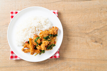 stir-fried fried fish with basil and chili in thai style topped on rice