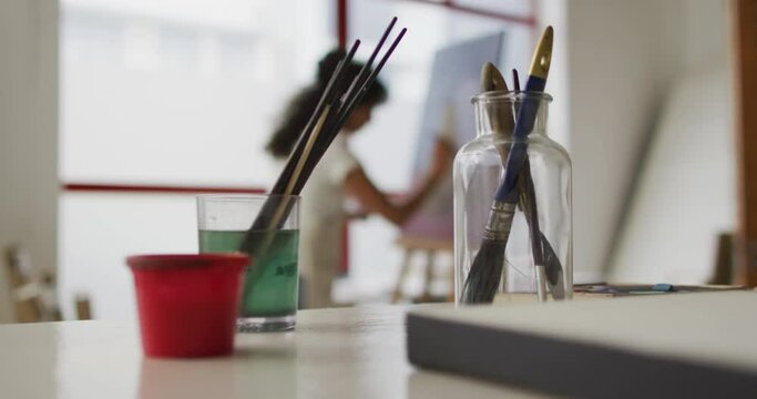 Art supplies in focus in a bright classroom, with copy space