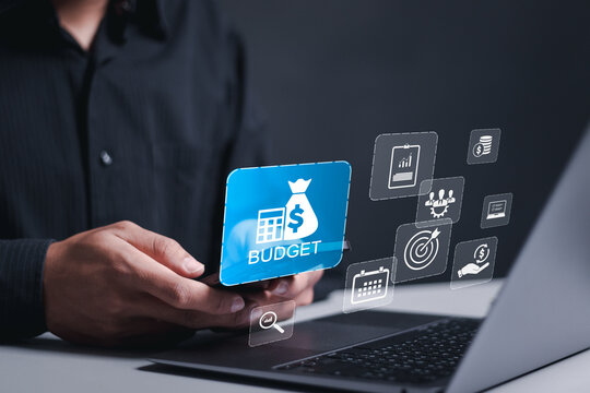 Budget and financial planning concept. Calculate company income and expenses. Corporate finance and annual strategic plan. Businessman use laptop with budget icon on virtual screen.