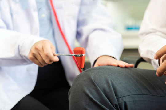 Doctor use hammer knock senior patient to check knee reflex, nerve and muscle in hospital.