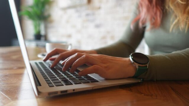 Close-up of a woman's hands typing on a laptop 