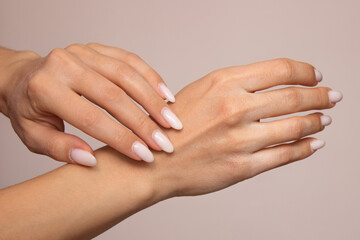 Chapped female hands close-up with dry skin and cracks on the fingers. Isolated on a light background. Horny white cuticle at the base of the nails. Sensitive skin care concept