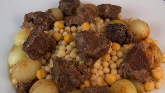 Moughrabieh is a popular dish in the Lebanese cuisine, LEBANESE RECIPE FOR MOUGHRABIEH WITH BEEF AND SMALL ONIONS, SEMOLINA PEARLS AND CHICKPEAS. High quality video