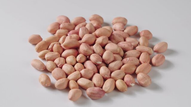 peeled raw peanut kernel on white background.