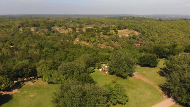 zoom out de toma de drone de un sitio glamping en mediode la naturaleza del bosque y monta&ntilde;as