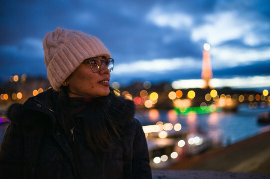 Asian woman near the Seine river at night, Paris, France