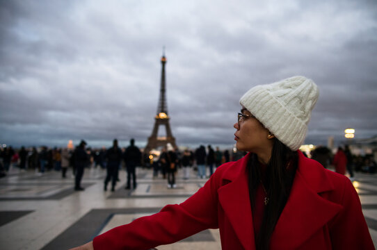 Asian woman near the Eiffel tower on a cloudy winter day,, Paris, France