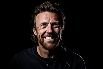 Portrait of a happy mature man with a beard on a black background.
