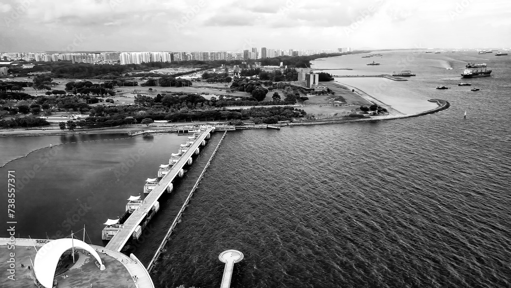 Wall mural Marina Barrage, Singapore: Aerial view of cityscape and coastline on a overcast afternoon