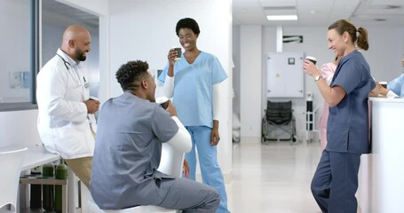 Diverse healthcare professionals share a light moment in a hospital