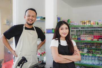 Confident young Asian people as convenience store staff in apron standing with arms crossed smiling to camera.