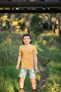 Portrait of happy boy wearing yellow shirt in Australian country bush setting