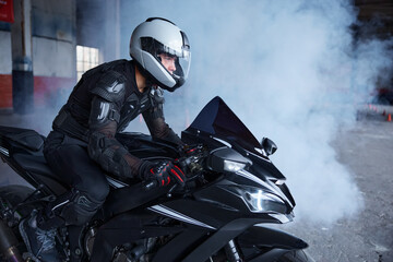 Biker wearing protective helmet and uniform for speed riding at training class