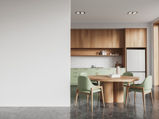 White and green kitchen interior with dining table and blank wall