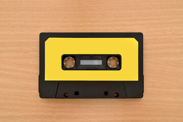 Old cassette tape on the brown wooden table. Vintage technology concept. Top view.