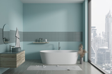 Elegant blue home bathroom interior with sink, bathtub and panoramic window