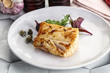 Roasted cod fish steak with salad