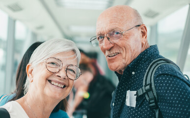 Portrait of happy senior couple travelers queuing for boarding on plane, tourism and vacation concept