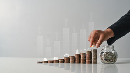 Hand stacking coins with heights up arrow icons. Income Management and saving money concepts