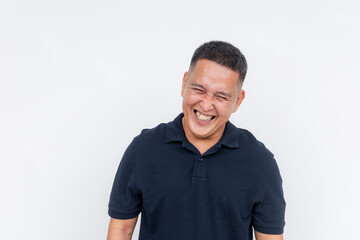 Obraz premium Portrait of a cheerful middle-aged Asian man laughing heartily, with a white background providing copy space.
