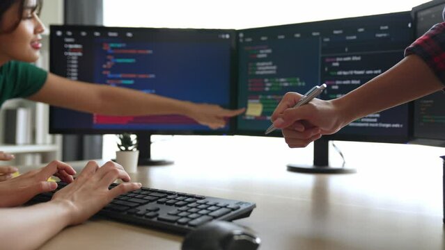 Slow motion back end software developer engineer for computer programming working together on debugging writing computing code, solving complex algorithms display on monitor in office. Burgeoning