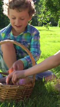 Two children boy and girl having easter egg hunt in garden backyard