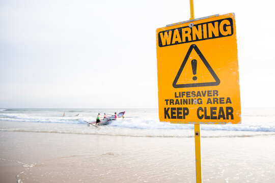 sign lifesavers training and a surfboat in the background