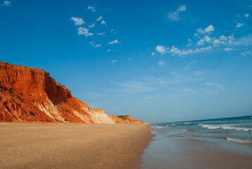 the deserted beach in front of the gigantic sand dunes on the coast of the Algarve Portugal