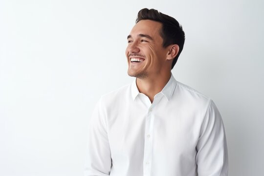 Handsome young man in white shirt smiling and looking up.