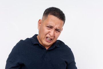 Obraz premium A revolted middle aged Asian man displaying a disgusted expression, isolated on a white background conveying repulsion.