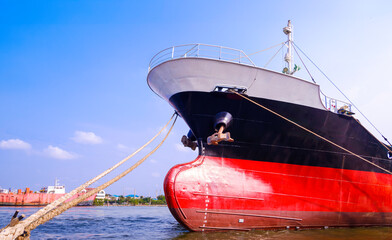 Oil tanker ship moored at shipyard during improvement and renovation work against blue sky...
