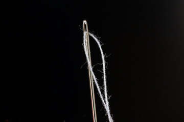 thread threaded into a sewing needle