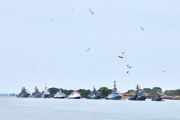 Airborne forces paratroopers flying Russian flag over naval forces parade warships along coastline,...