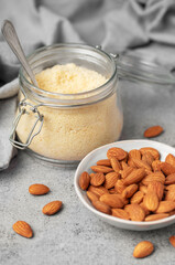 Fresh almond flour in a  glass jar and almonds