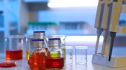 Scientists are doing research in a science lab. A medical chemist in a white coat, gloves and...