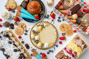 assortment of ice cream cakes and pastries from above on white horizontal table