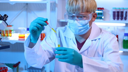 Scientists are doing research in a science lab. A medical chemist in a white coat, gloves and...