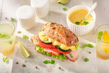 Tasty sandwich served with lemonade in the kitchen.
