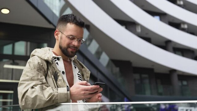 Young independent hipster businessman freelance motivational speaker life coach standing in front of office building preparing for staff meeting. Businessperson product strategy expert waiting