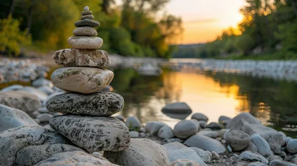 Wandaufkleber Oval stones stacked on the riverside © Jennifer