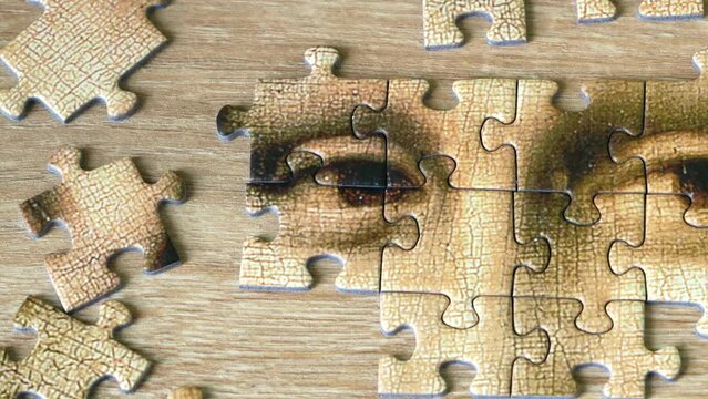 Jigsaw Puzzle Of Female Face Mona Liza La Gioconda from Leonardo Da Vinci, from ancient painting on wooden background,